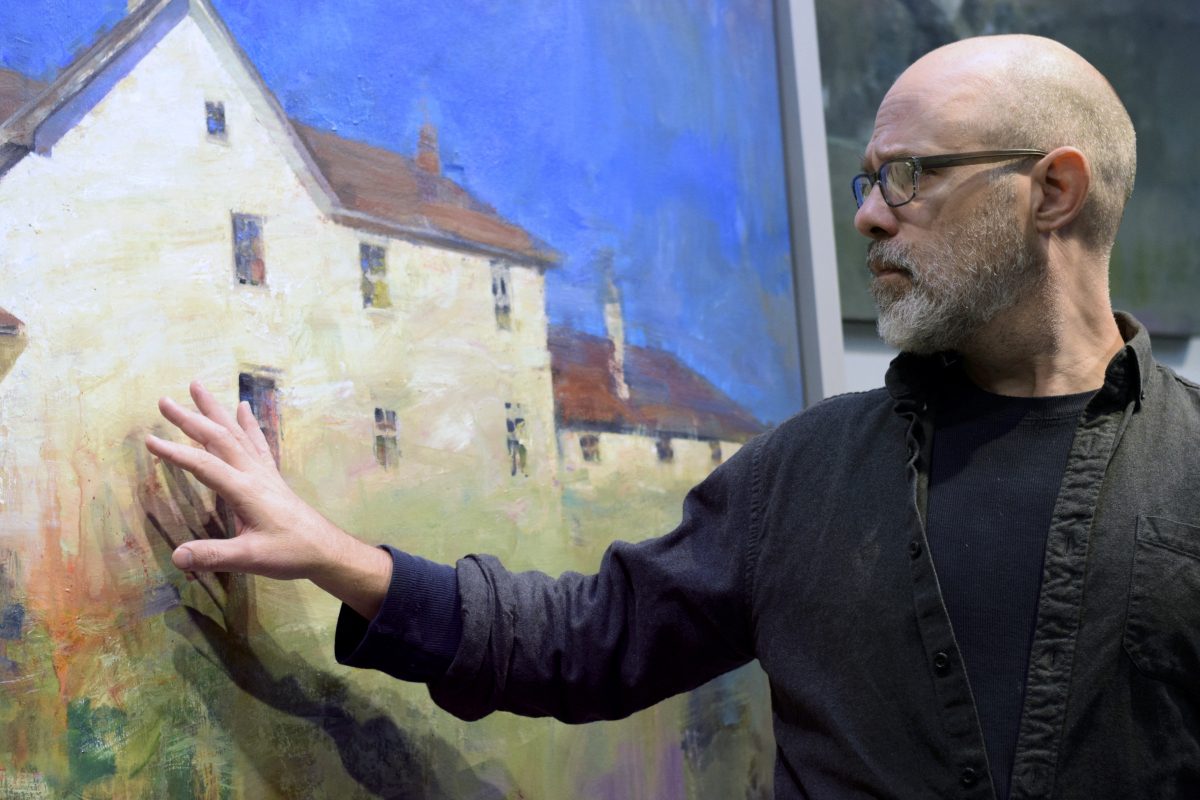 Painter showcasing house painting in studio