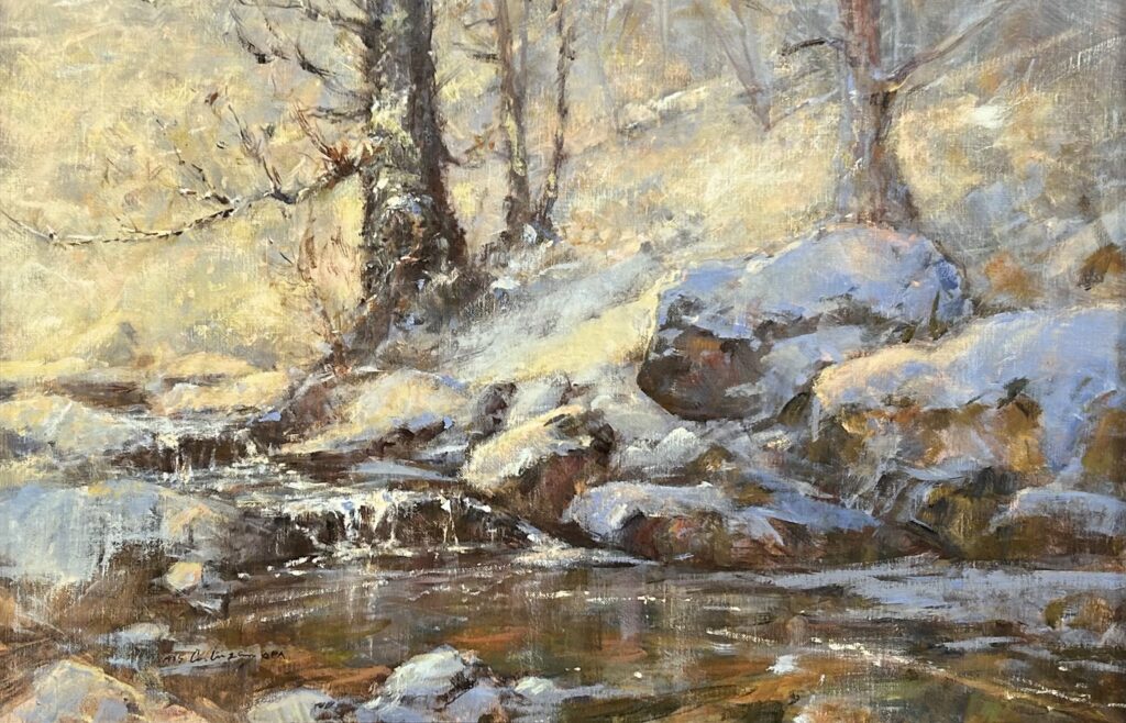 A serene winter landscape with snow-covered rocks and trees by a calm stream.