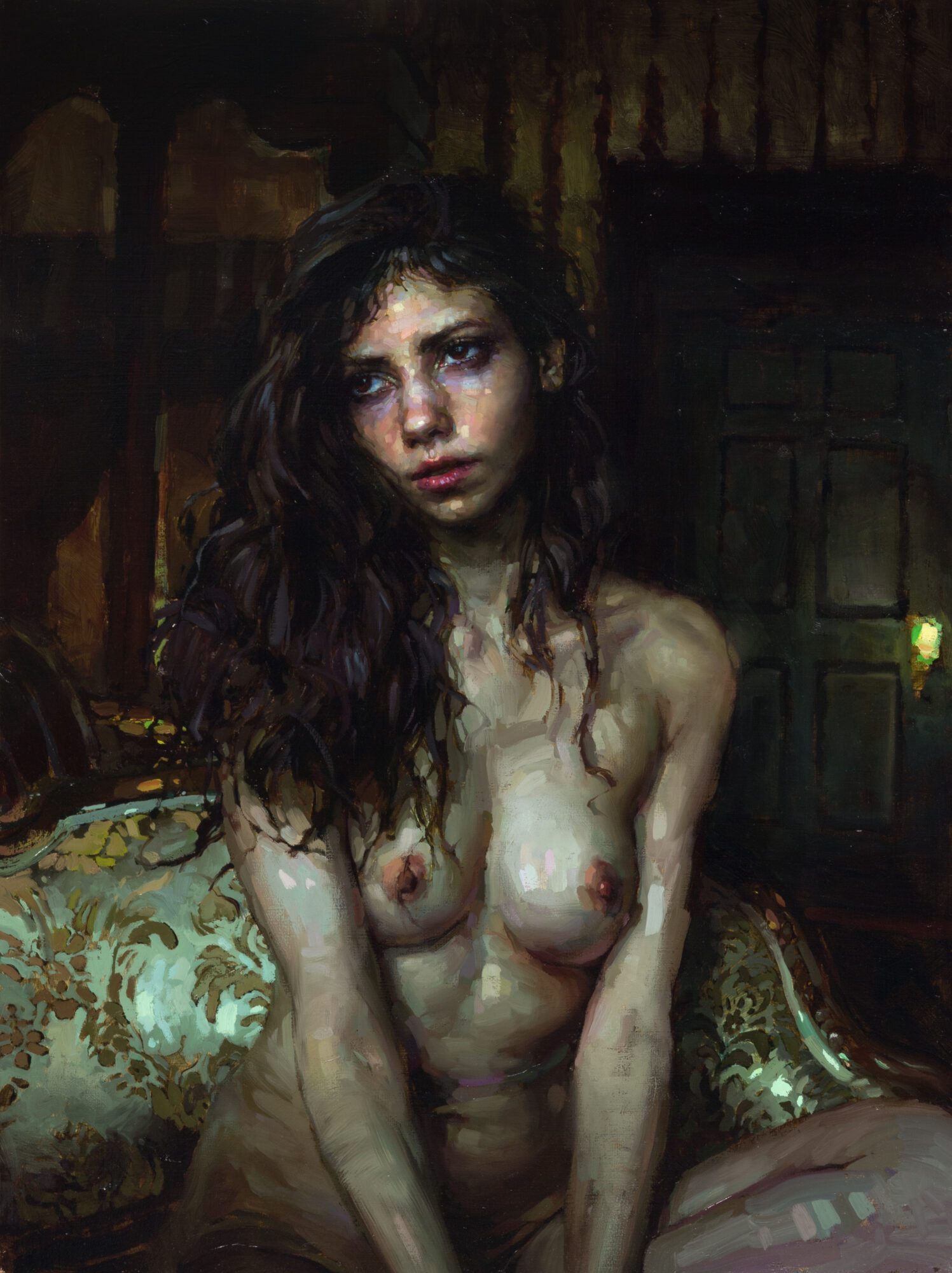 Artistic nude portrait of a woman with long, curly hair in a dimly lit room.