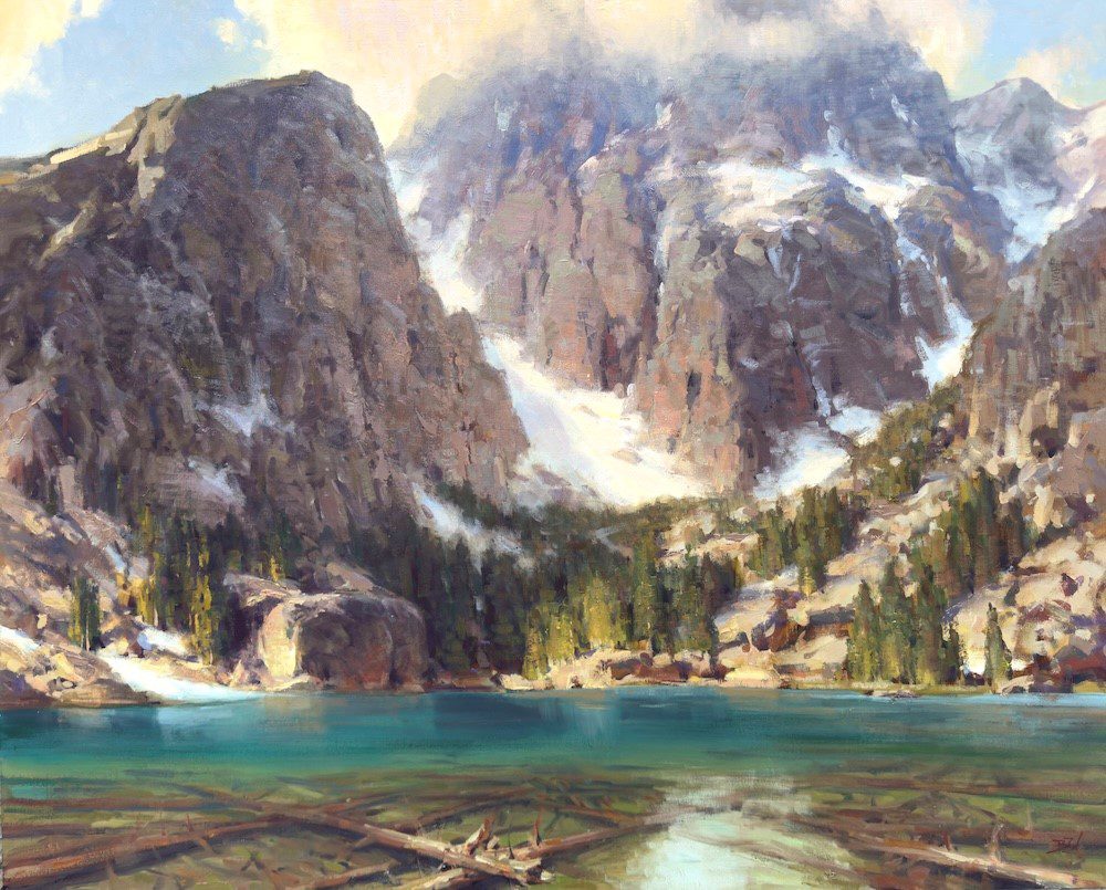 Snowy mountains with a clear turquoise lake and a small wooden dock.