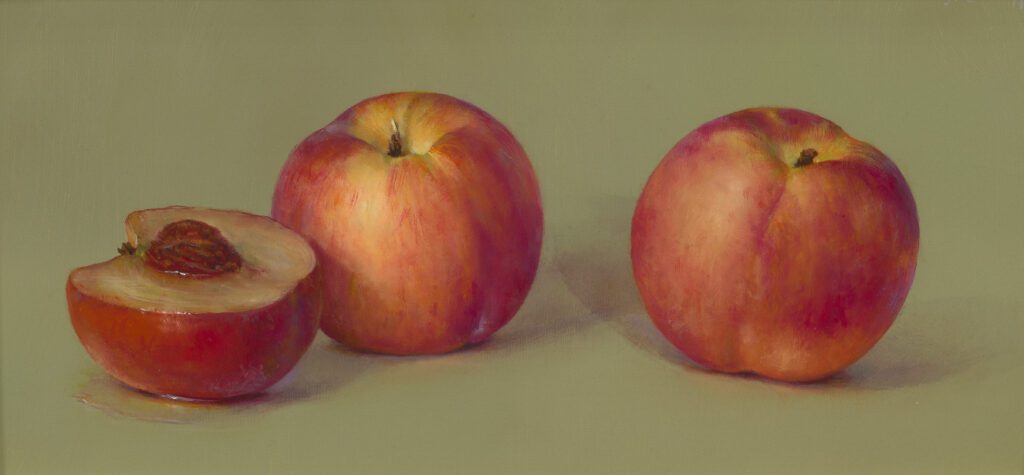 Two whole apples and one half apple on a neutral surface.