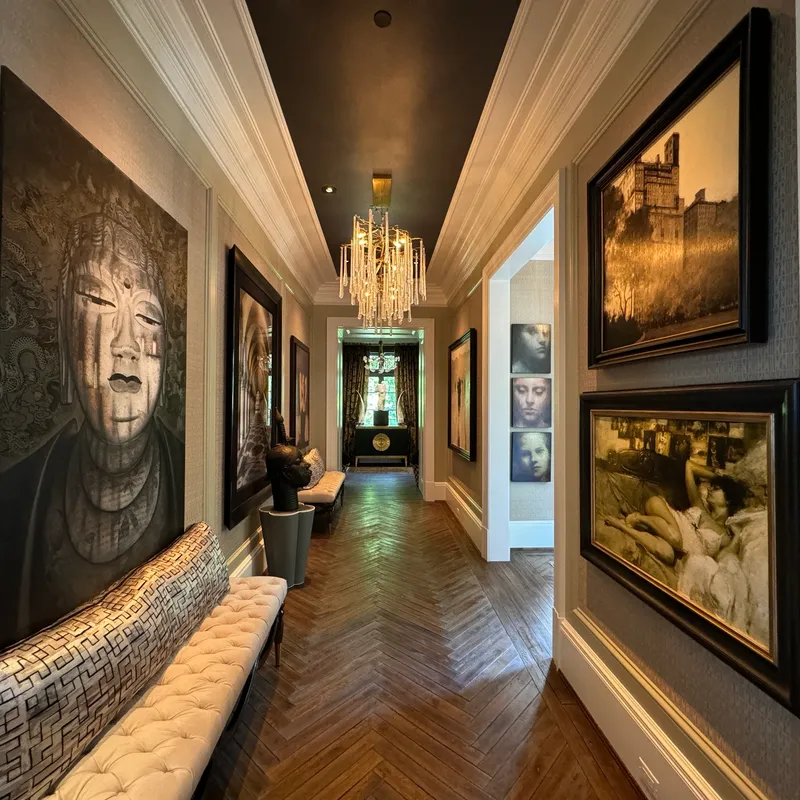 Elegant hallway adorned with modern art and a chandelier.