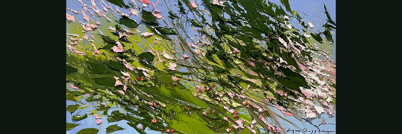 Close-up of a tree branch with green leaves and pink blossoms against a blue sky.