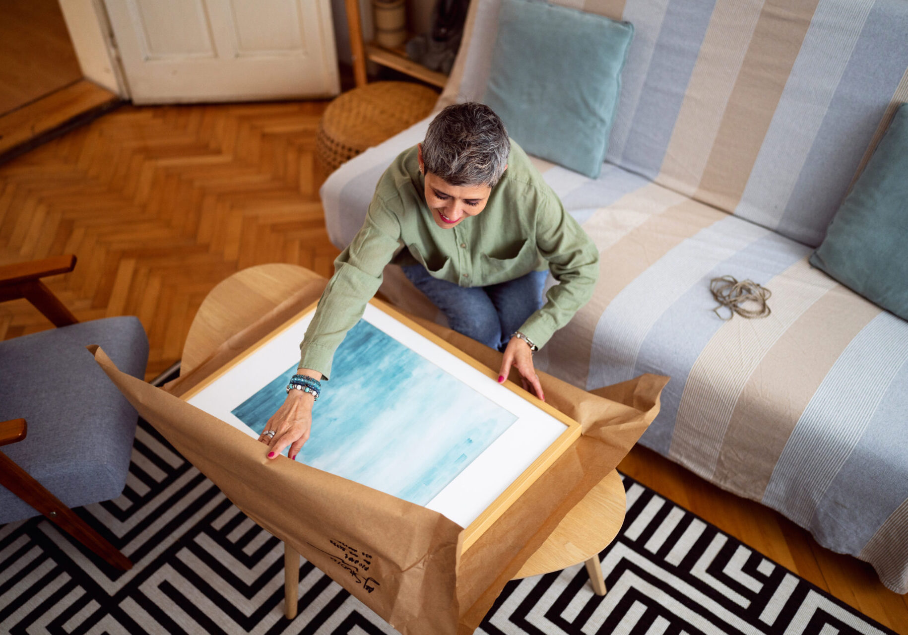 Man assembling a piece of furniture in a living room.